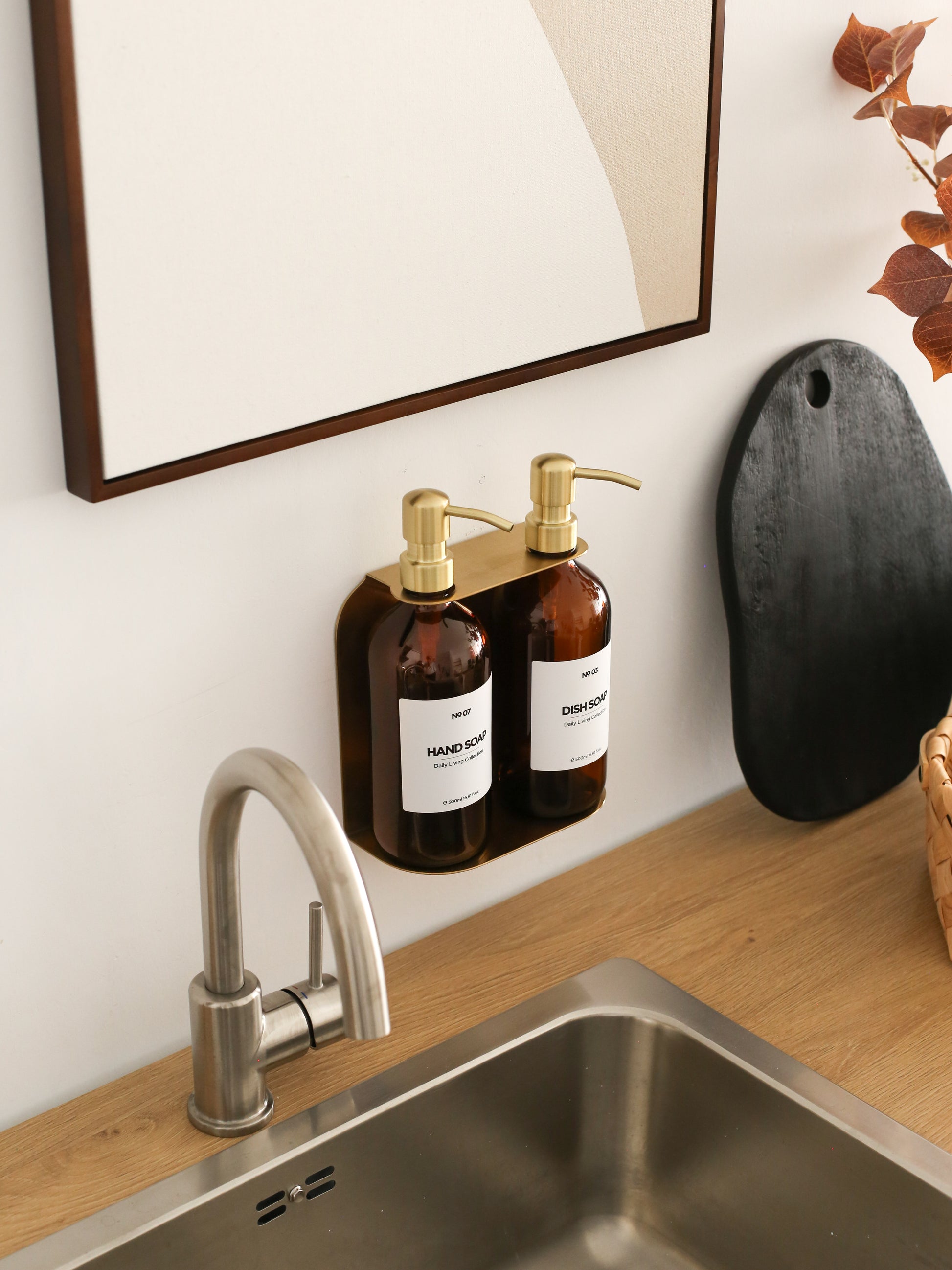 Shows wall mounted refillable soap dispenser set in kitchen